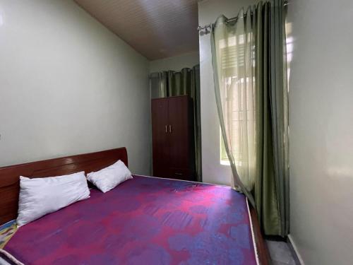 um quarto com uma cama com uma colcha colorida em MyPlace Suites 2-Bed Apartment Kagarama Kigali em Kigali