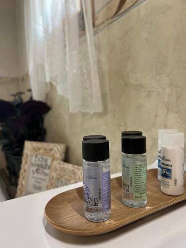 a wooden tray with three bottles of moisturizers on it at Florence Dreaming House in Pissouri