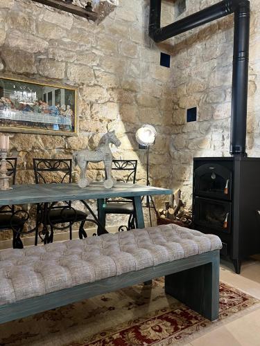 a stone walled room with a table with a horse statue on it at Florence Dreaming House in Pissouri