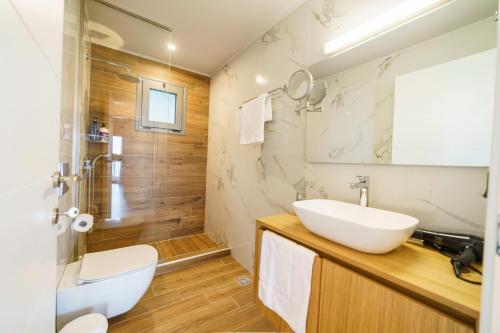 W łazience znajduje się biała umywalka i prysznic. w obiekcie Royal Hill Villa - Private Pool - Sleeps 8 w mieście Hersonissos