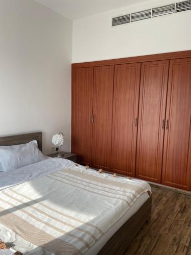 a bedroom with a large bed and wooden cabinets at J V Dubai in Dubai