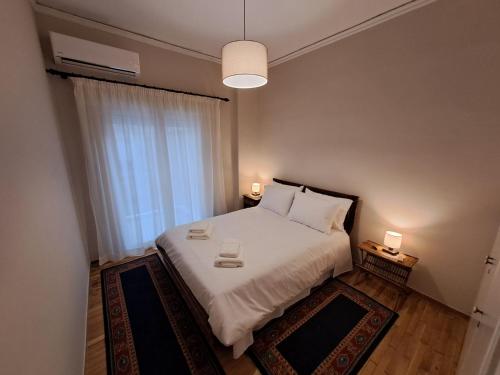 sypialnia z dużym białym łóżkiem i oknem w obiekcie Patras Stay w mieście Patras
