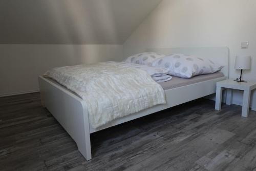 a bedroom with a white bed and a table at Ruhige Ferienwohnung in der Kernstadt Laubach in Laubach