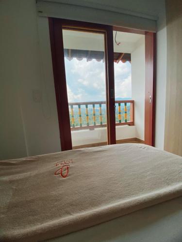 a bedroom with a bed with a view of a window at Loma Rent Home Guatape in Guatapé