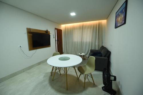 uma sala de estar com uma mesa e um sofá em Apart Hotel Neri em Sinop