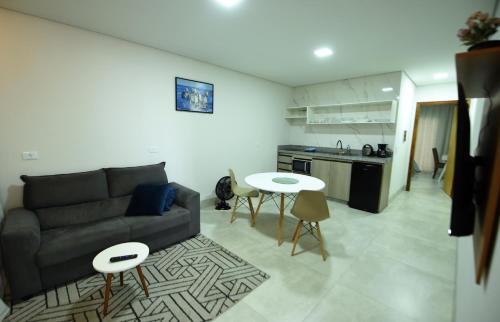 uma sala de estar com um sofá e uma cozinha em Apart Hotel Neri em Sinop