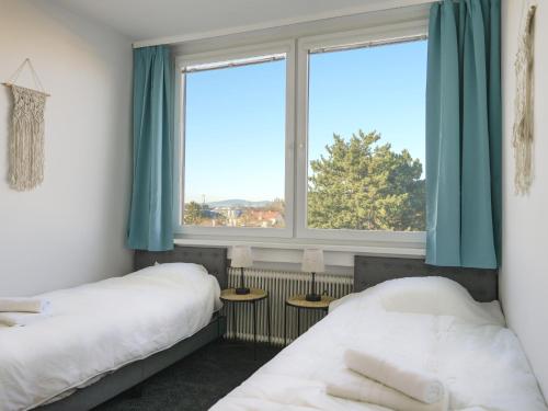 two beds in a room with two windows at Spacious Apartments with View & Free Parking in Wiener Neustadt
