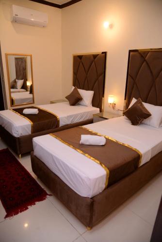 a hotel room with two beds and a mirror at Go Guest House Lahore in Lahore