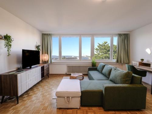 sala de estar con sofá y TV en Spacious Apartments with View & Free Parking, en Wiener Neustadt