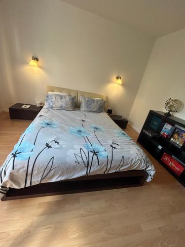 a bedroom with a bed with a blue comforter at "Spacious Family Apartment & Parking near Strasbourg Center with easy bus Access" in Bischheim
