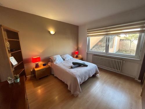 a bedroom with a bed with two lamps and a window at "Spacious Family Apartment & Parking near Strasbourg Center with easy bus Access" in Bischheim