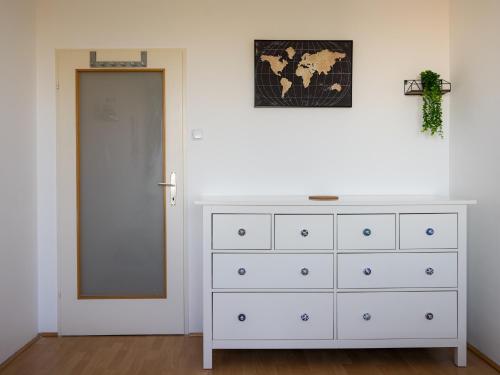 a white dresser with a mirror next to a door at Spacious Apartments with View & Free Parking in Wiener Neustadt