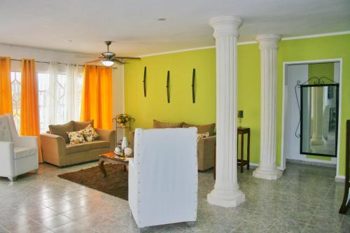 una sala de estar con paredes amarillas y columnas blancas en Camu, en Camú
