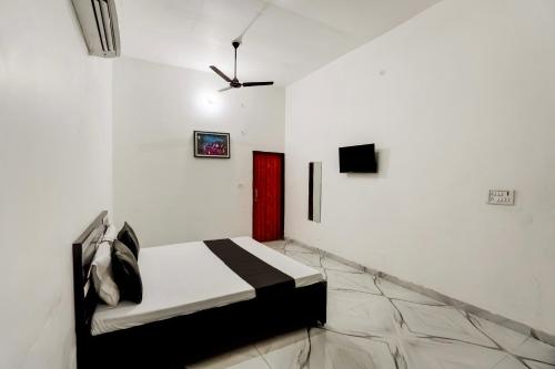 Habitación blanca con cama y puerta roja en OYO Meenaachi Inn, en Chennai