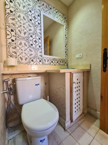 a bathroom with a toilet and a mirror at Maison d'hôte Bousaid in Chefchaouene