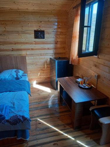 una camera con un letto e un tavolo in una baita di tronchi di Эко Аура a Areguni