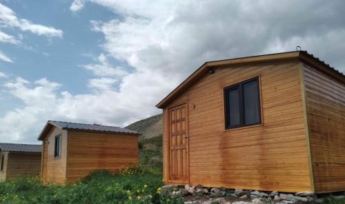 eine Holzhütte mit einem Fenster neben einem Haus in der Unterkunft Эко Аура in Areguni