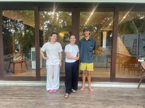 a group of three people standing in front of a building at Thalangama Lakeview Lodge in Battaramulla
