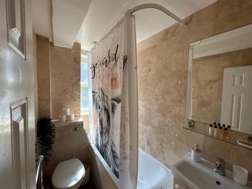 a bathroom with a toilet and a shower curtain at Marble Arch 3-Bedroom Family Flat in Central London in London