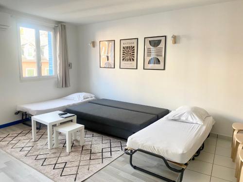 une chambre avec deux lits et une table dans l'établissement Hébergement du Bourg, à Lourdes