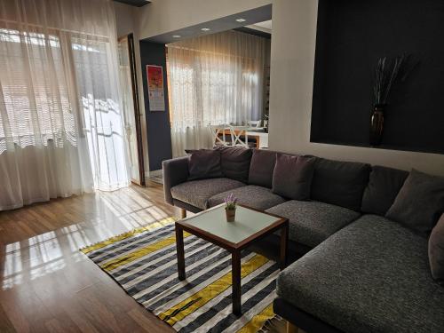 a living room with a couch and a coffee table at Grey central apartment in Varna City