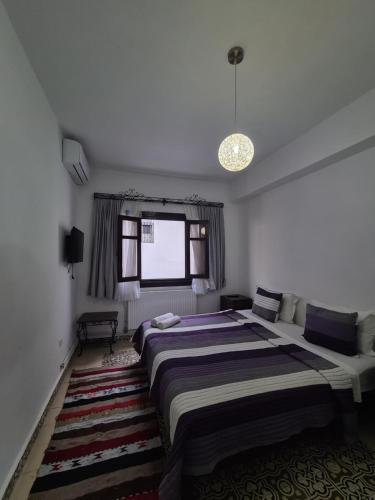 a bedroom with a large bed and a window at Maison d'hôte Bousaid in Chefchaouene