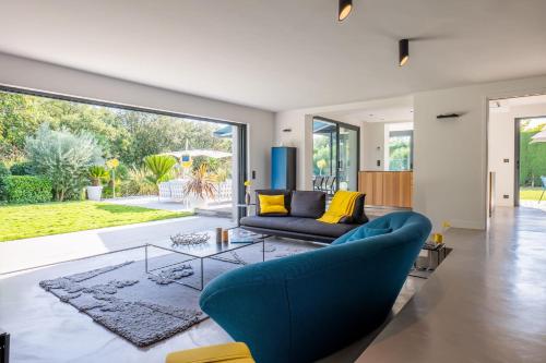 uma sala de estar com um sofá azul e uma mesa de vidro em Vacation villa swimming pool and pétanque court ! em Biot