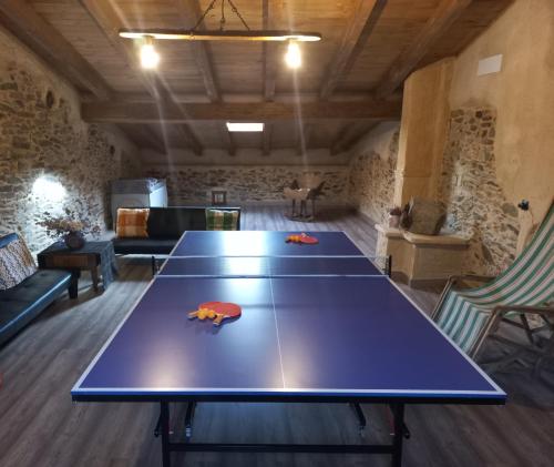 a ping pong table in a room with two tables at Casa Rural La Moraquintana in Santibáñez el Bajo