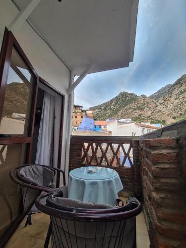 a table and chairs on a balcony with a view at Maison d'hôte Bousaid in Chefchaouene