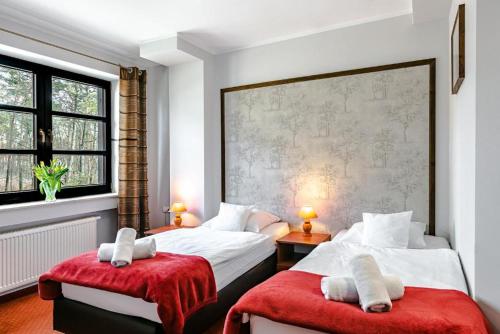 1 dormitorio con 2 camas con cojines rojos en Browar Gościniec Chojnice, en Chojnice