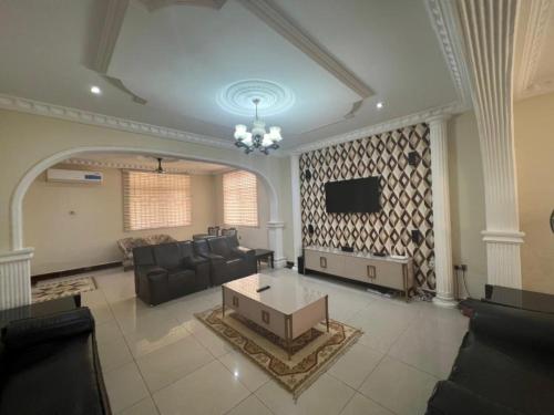 a large living room with couches and a tv at Rose Villa in Spintex