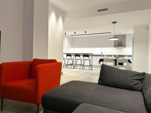 a living room with a red chair and a kitchen at Esteve Silence in Valencia