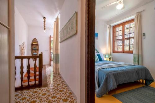 1 dormitorio con 1 cama y pasillo con ventana en Villa Elicriso Le Bombarde, Alghero, en Alghero