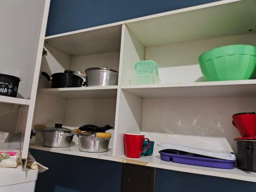 a kitchen pantry with pots and pans on shelves at Kitnet Aconchegante in Foz do Iguaçu