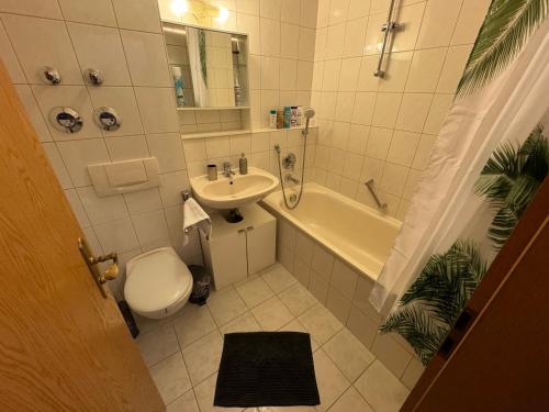 a bathroom with a toilet and a sink and a tub at Kingsize Bett BOHO Apartment mit Tiefgarage nähe Salzburg in Freilassing