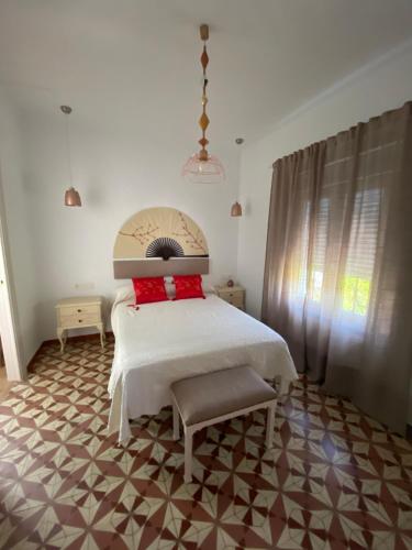 a bedroom with a white bed with red pillows on it at La casa de Alejandra, planta alta. in Perales del Puerto