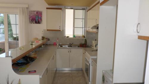 a kitchen with white cabinets and a sink and windows at Chania City Apartments in Chania