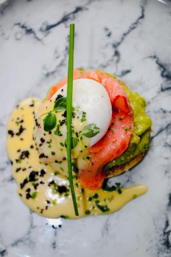 een bord met eten, met een ei bovenop een sandwich bij Sorobon Luxury Beach Resort in Kralendijk