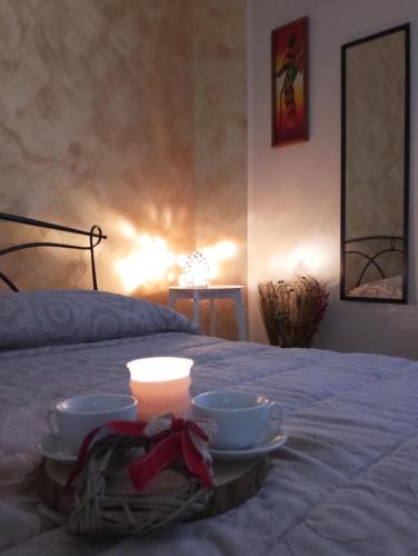 a table with two bowls and a candle on a bed at La ninfa B&B in Salerno