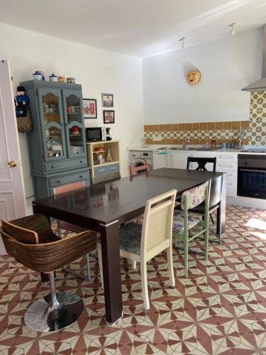 a kitchen with a dining room table and chairs at La casa de Alejandra, planta alta. in Perales del Puerto
