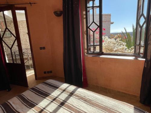 a bedroom with a bed and a window with a view at Dar Volubilis spacieuse villa avec piscine, 5 chambres vue sur forêt in Essaouira