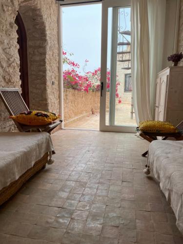 a room with two beds and an open door at Dar Volubilis spacieuse villa avec piscine, 5 chambres vue sur forêt in Essaouira