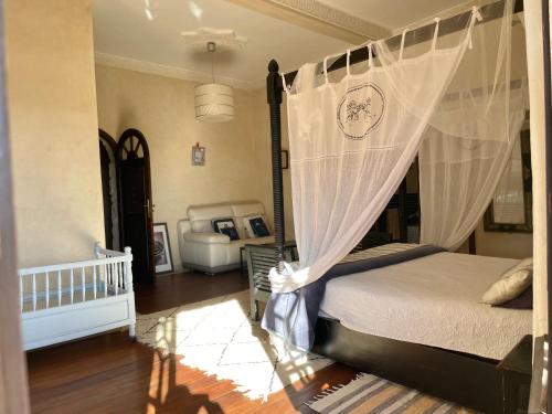 a bedroom with a bed with a canopy at Dar Volubilis spacieuse villa avec piscine, 5 chambres vue sur forêt in Essaouira