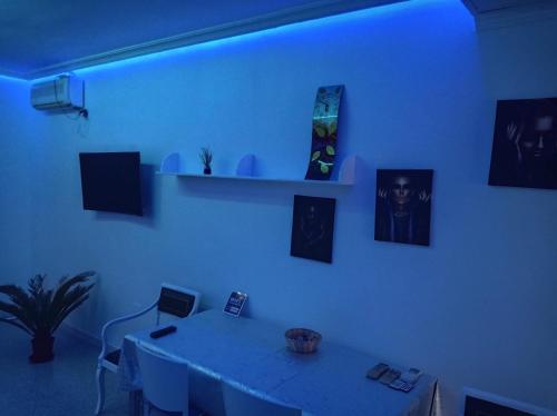 Habitación blanca con mesa y luz azul en Grande Piso Aguadulce & Spa, en Aguadulce