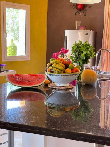 a bowl of fruit on a counter in a kitchen at Dar Volubilis spacieuse villa avec piscine, 5 chambres vue sur forêt in Essaouira