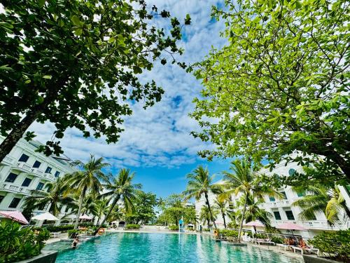 フーコックにあるChloe Marina Phu Quocのヤシの木が茂るリゾートの真ん中にあるスイミングプール