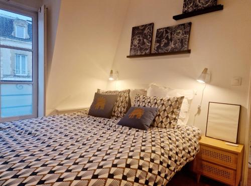a bedroom with a large bed with pillows on it at Chez Valérian, gare de Chantilly in Chantilly