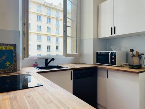 une cuisine avec un évier et un micro-ondes dans l'établissement Le Zeus - Cannes Villa St Henri seafront unique 2bedrooms, à Cannes