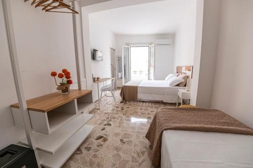 a hotel room with two beds and a desk at B&B - Le Tre Comari in Ragusa