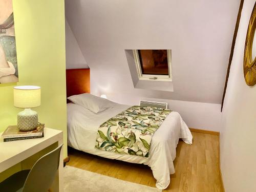 een kleine slaapkamer met een bed en een raam bij Le K-rouge in Carrouges